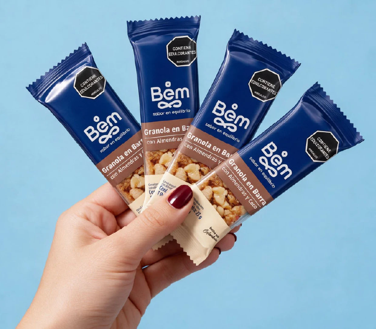 Mano con barras de granola con almendras y coco Bem